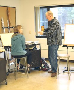 David Boggs gives advice on watercolor painting techniques to one of his students, Helena Langr. Photo by Maddie Malat.