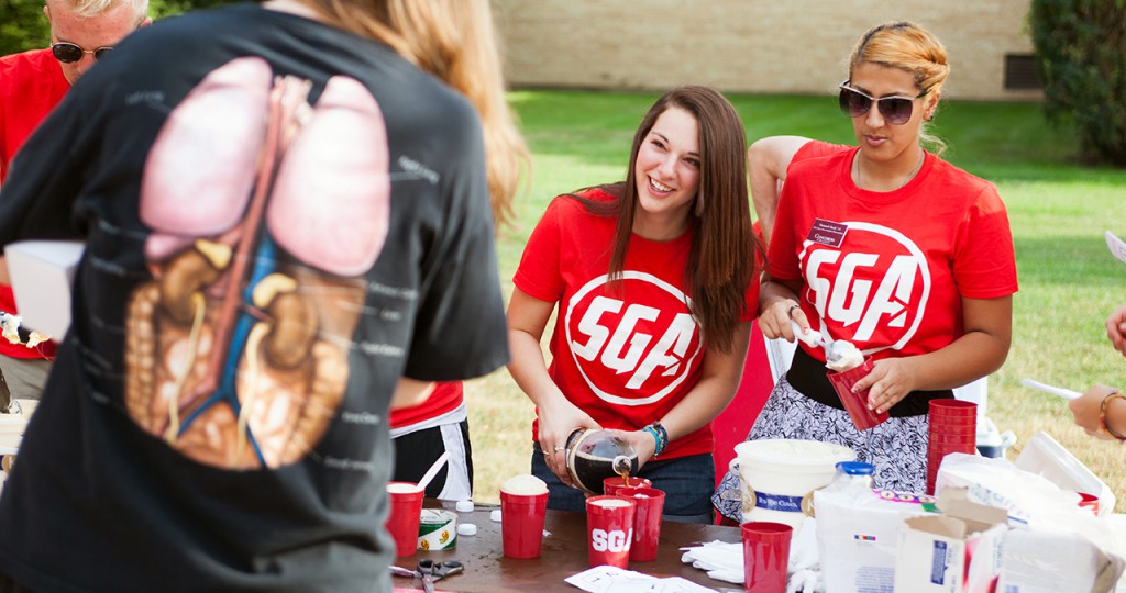 SGA members Carly Grandner and Hananeh Saedi prepare root beer floats at Cobber Expo. Photo by Chase Body.