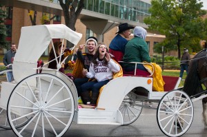 Homecoming King and Queen Colin Sullivan and Carly Grandner ride in the homecoming parade Sauterday, Oct. 12. Despite the dreary weather, the parade still represented a large portion of the campus community with around 100 floats. Photo by Chase Body.