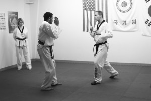 Master Dave Schimmelpfennig instructs Stephen Oppegaard on the practices of taekwondo. Photo by Maddie Malat.