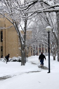 Student rushes to class as Concordia staff member shovels fresh snow. Photo by Hans K. Peter.