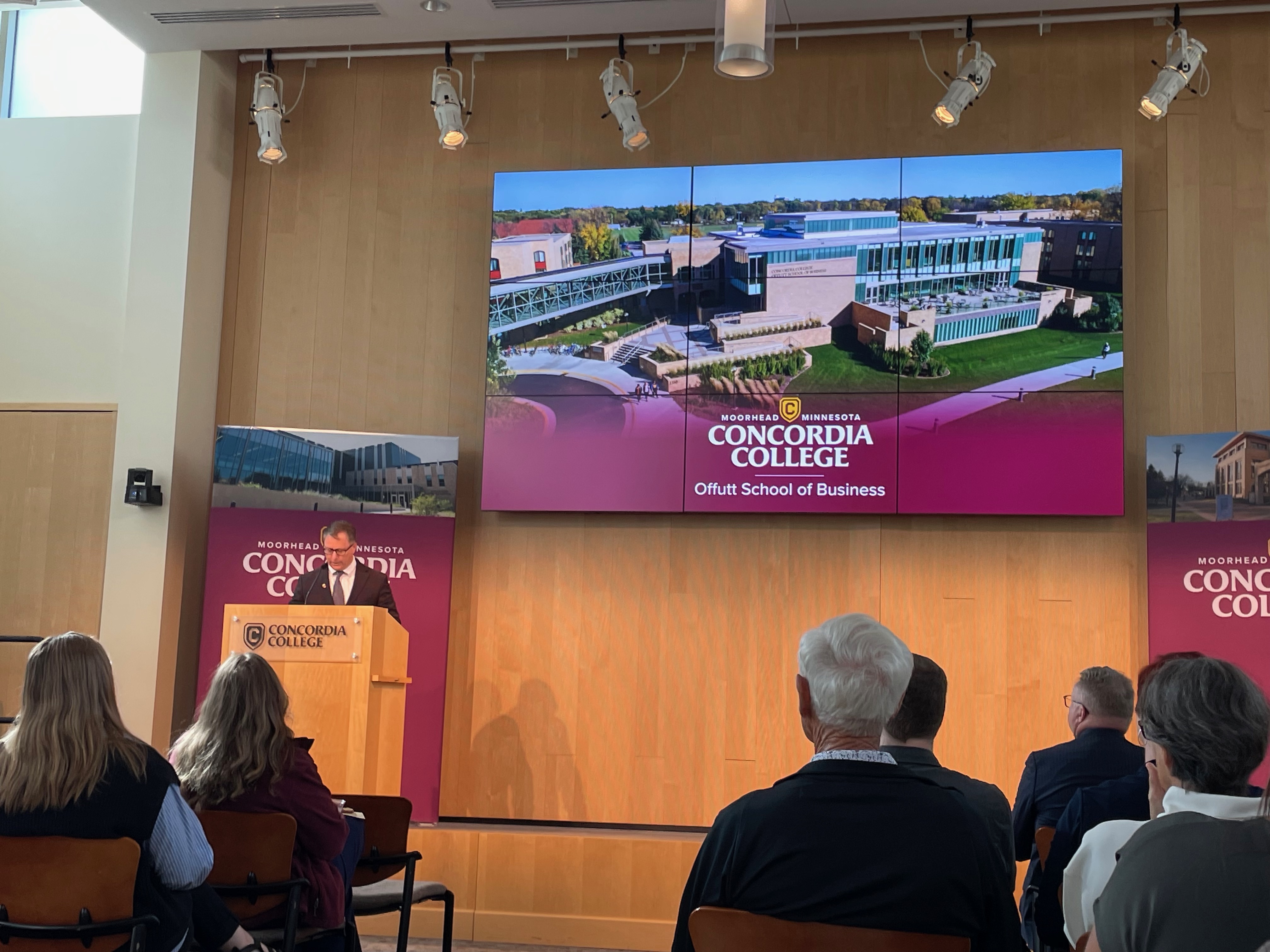 Large television screen picturing Offut School of Business with President Irvine standing in front